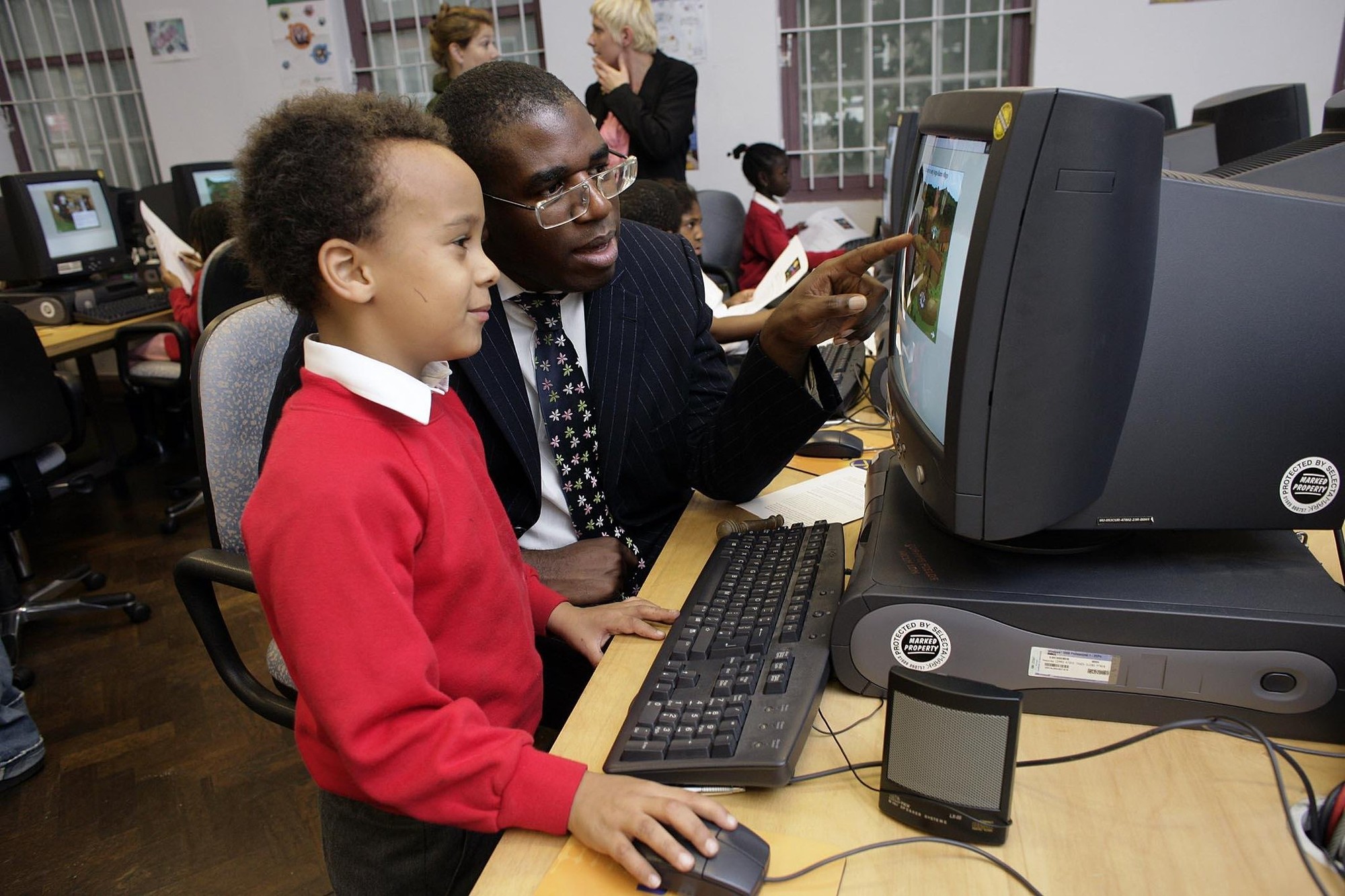 Culture Minister David Lammy tries out the new web site with some help form Apollinaire (7) from St George The Martyre School. The launch of the web site was at Coram's Fields, Guilford Street, WC1N. Photo: Edmond Terakopian / PA
